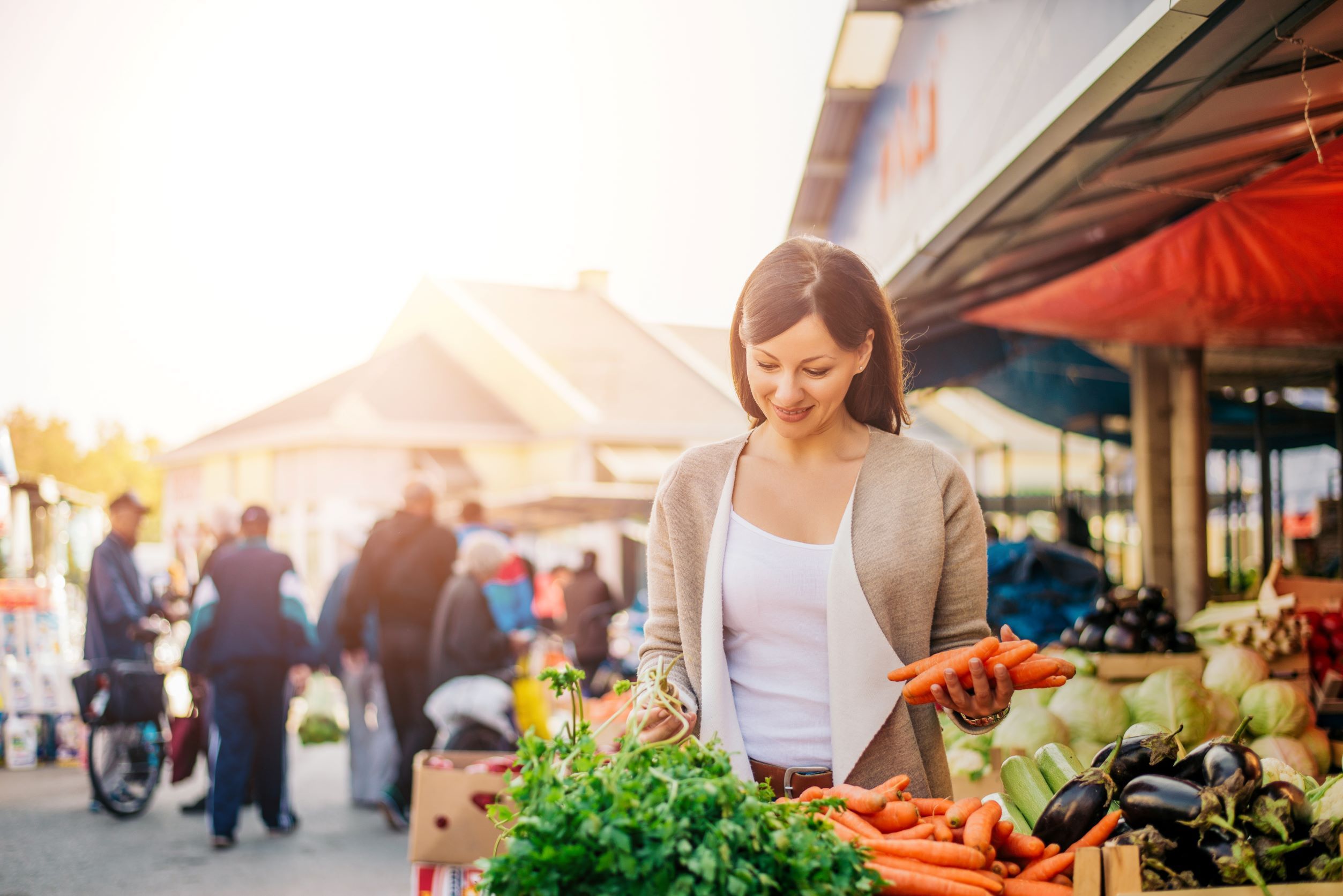 Junge Frau kauf Gemüse auf dem Markt